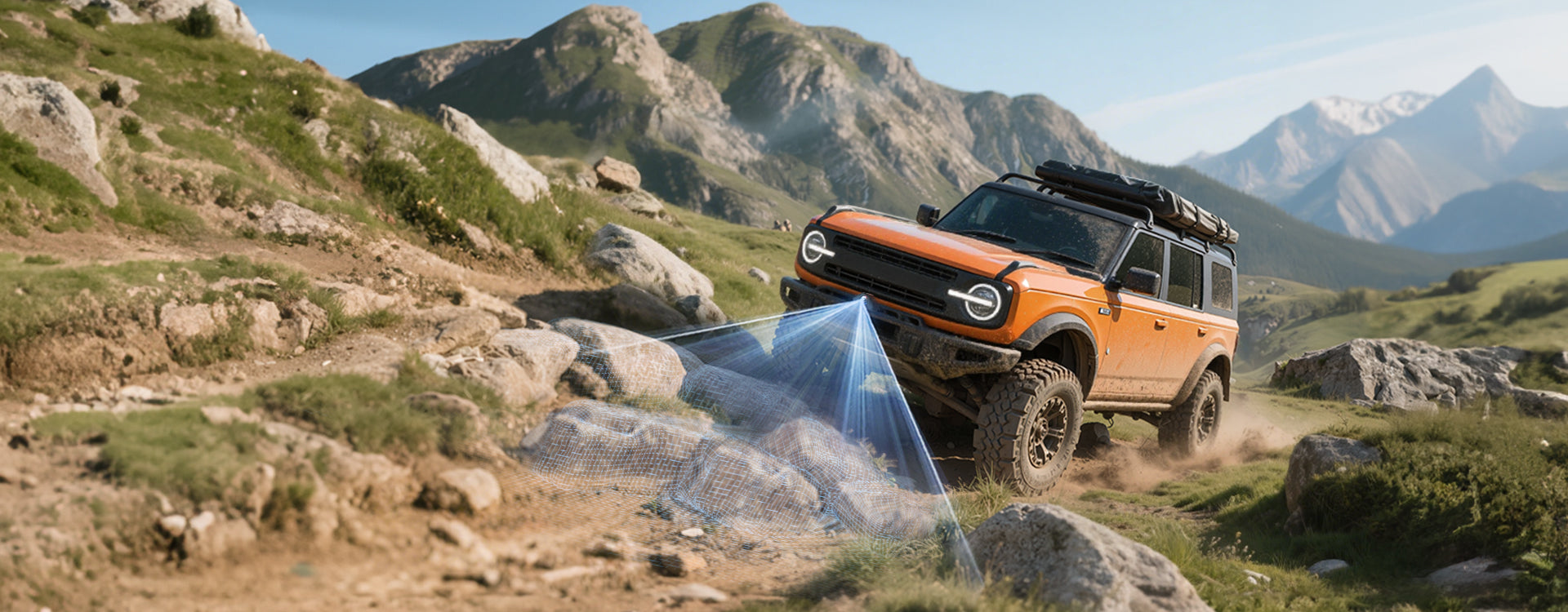 Orange off-road vehicle on a rocky hillside with mountains in the background