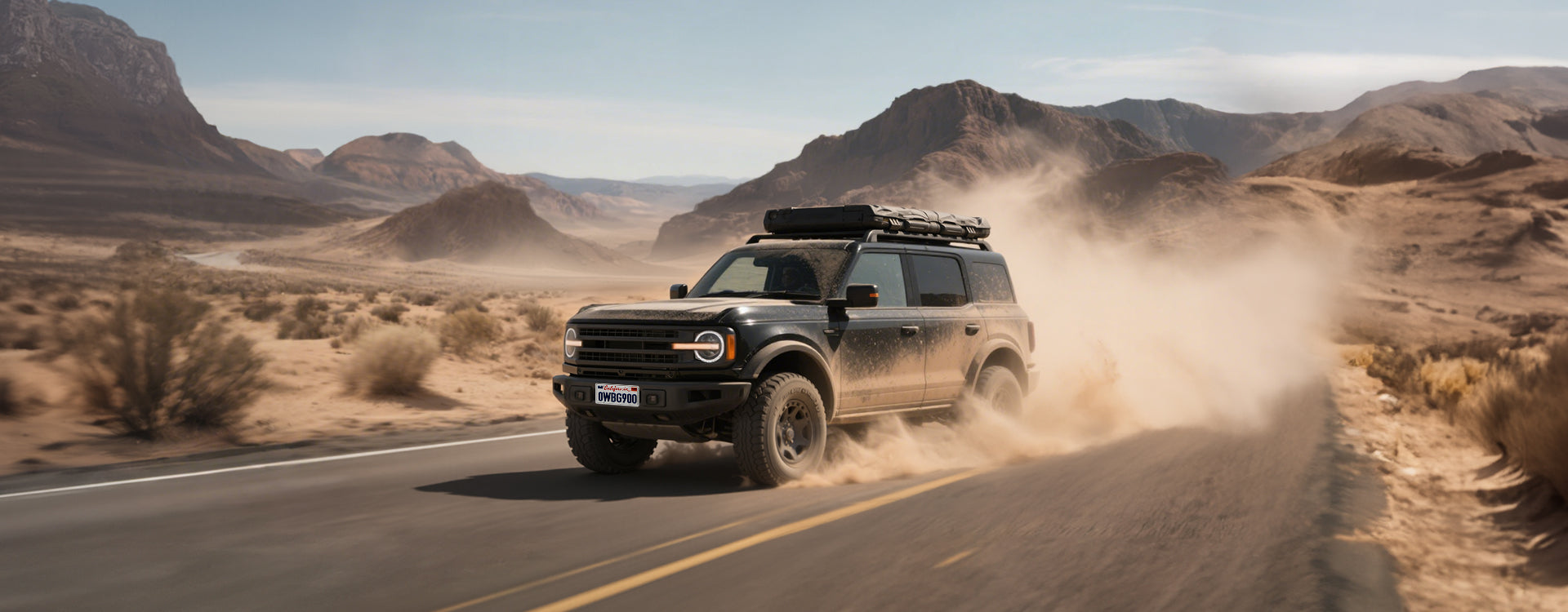 Suv driving on a desert road with mountains in the background